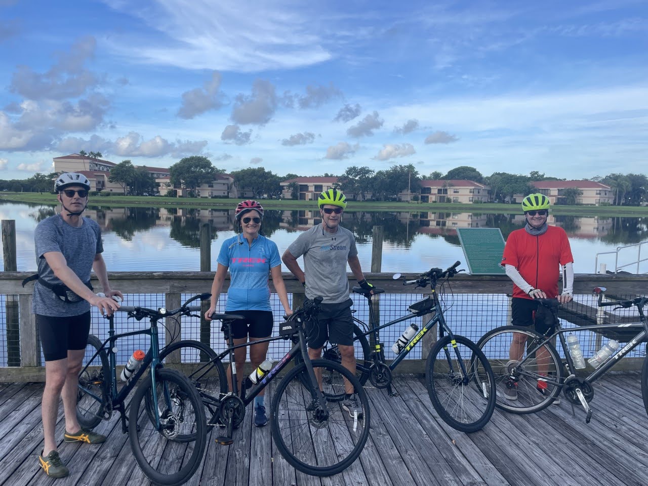 Four people pose with their Trek bikes overlooking intertidal waters in Coconut Creek Florida Four people pose with their Trek bikes overlooking intertidal waters in Coconut Creek Florida